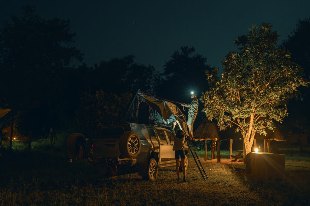setting up a rooftop tent at night 