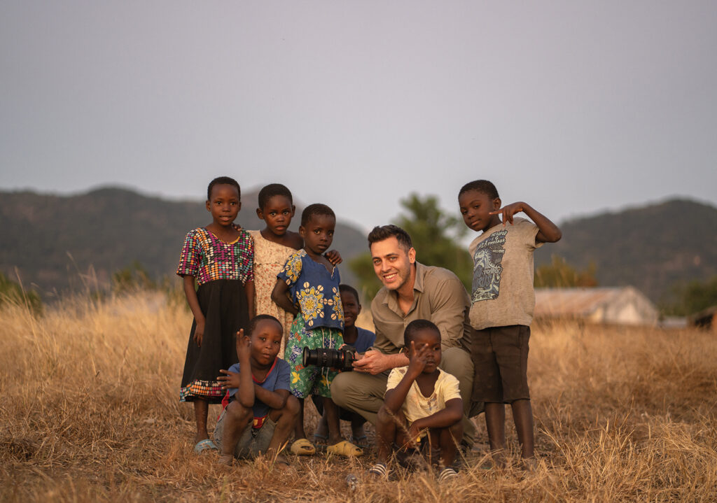 white guy in between african kids 