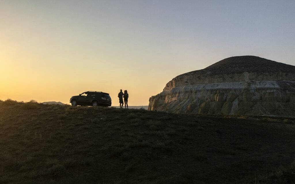 a couple near mount sherkala at sunset 